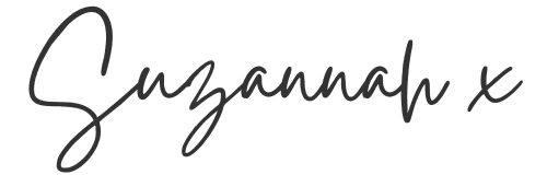 The word "Suzannah" followed by the letter "x," written in a black handwritten script on a light background.